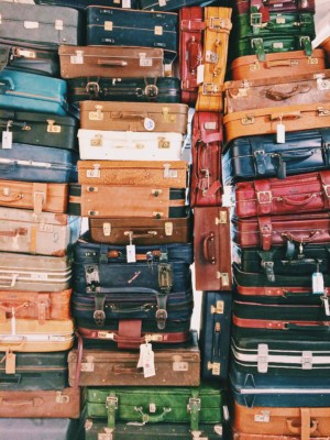 Suitcases of different colours packed on top of each other
