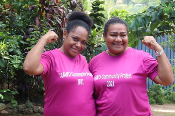 Two women pose in preventing gender-based violence project t-shirts