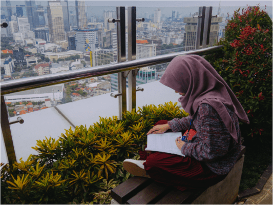 Girl sitting on a rooftop reading a book