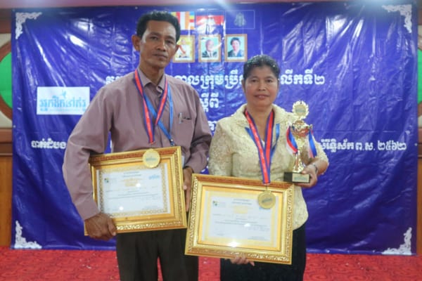 Two people holding awards