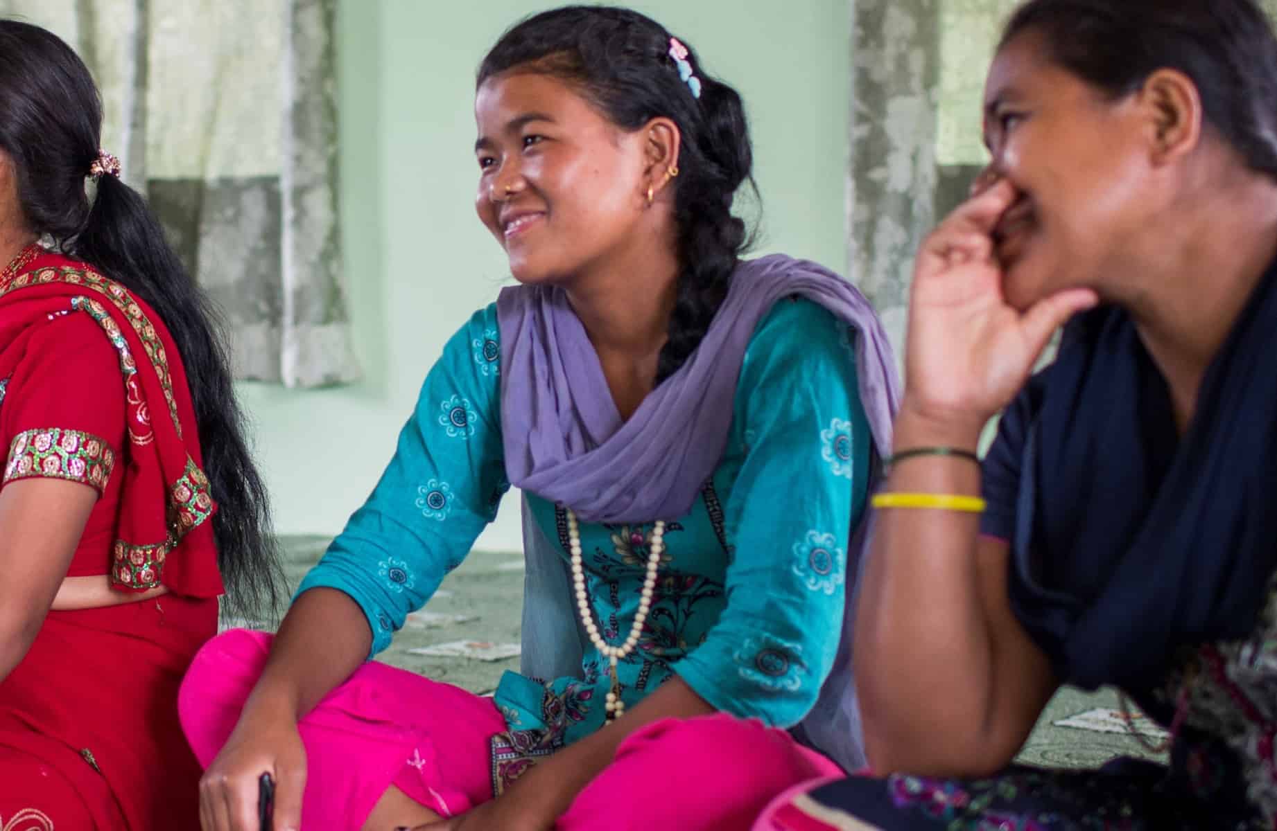 Women sitting on the floor and smiling