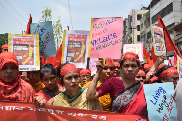 Bangladeshi women protesting with signs for workplace rights and maternity protection