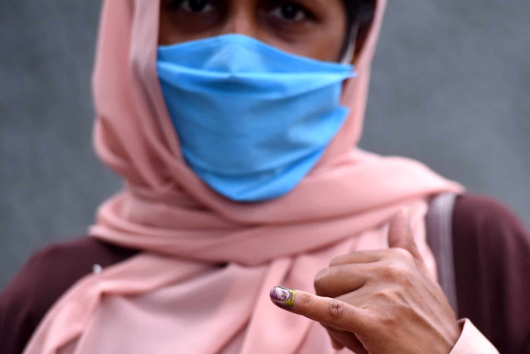 Woman holding up inked finger