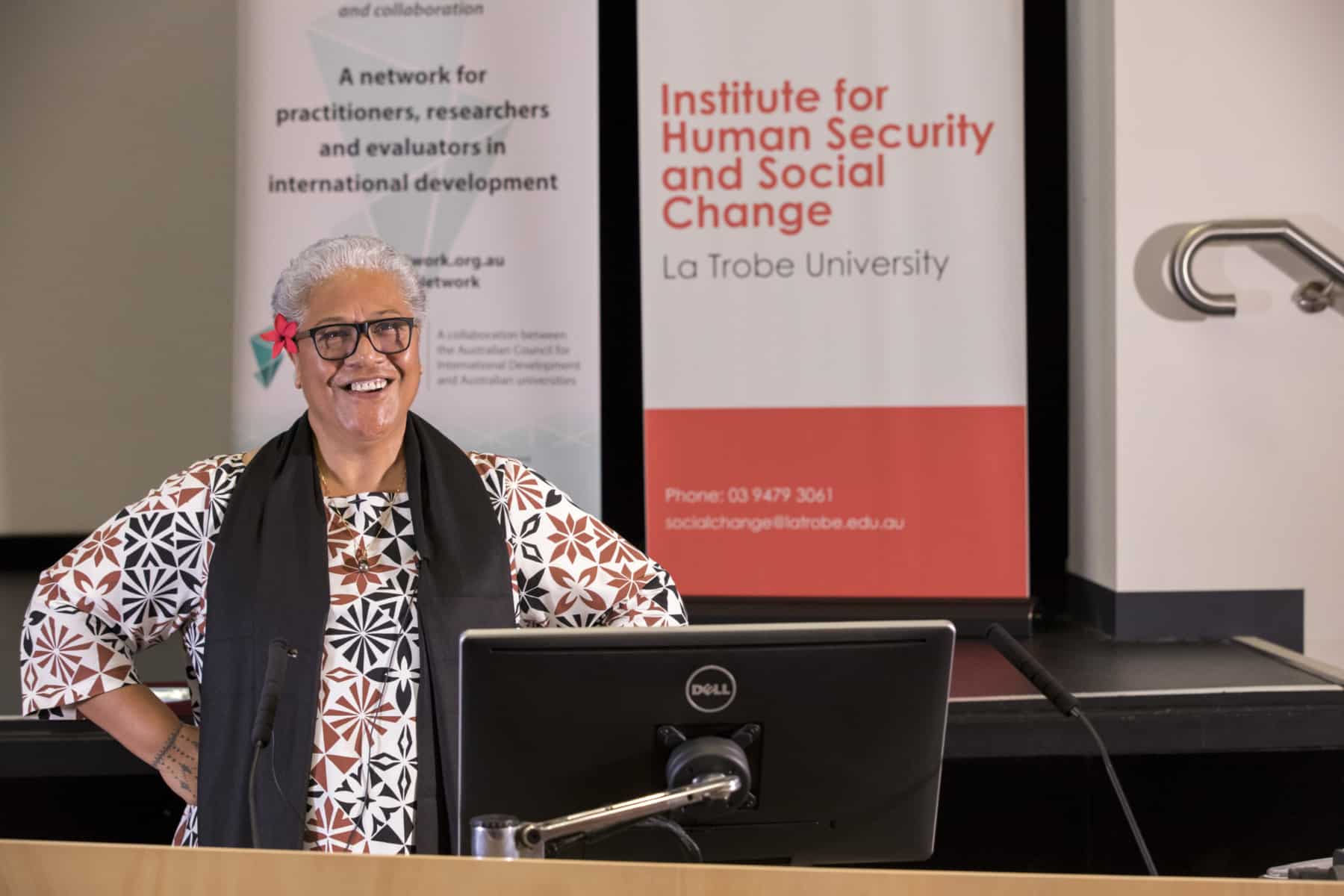 Woman standing beneath a sign reading 