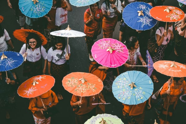 People in a crowd holding parasols