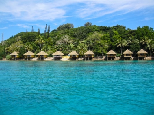 Water and island with trees and huts, Vanuatu
